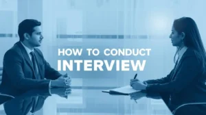 A man and woman in business attire sit across a table, engaged in conversation. Text reads "How to Conduct Interview." The tone is professional and focused.